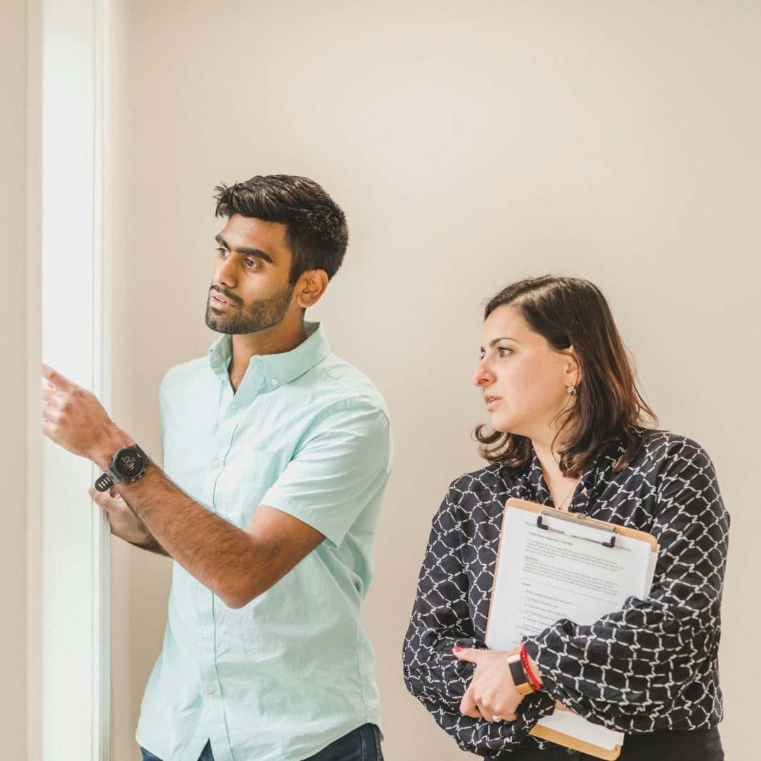Realtor showing a property to a client indoors, discussing details.